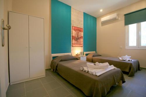 two beds in a room with blue walls at Seaside, relaxing family house with playground! Villa Lavrys 3 in Marathi