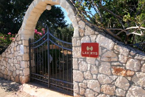 a gate in a stone wall with a sign on it at Seaside, relaxing family house with playground! Villa Lavrys 3 in Marathi