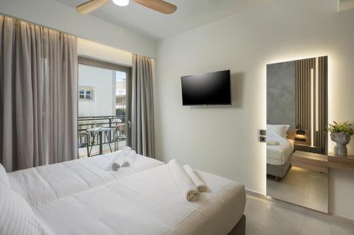 a hotel room with two beds and a television at Alkionides Seaside Hotel in Plataniás