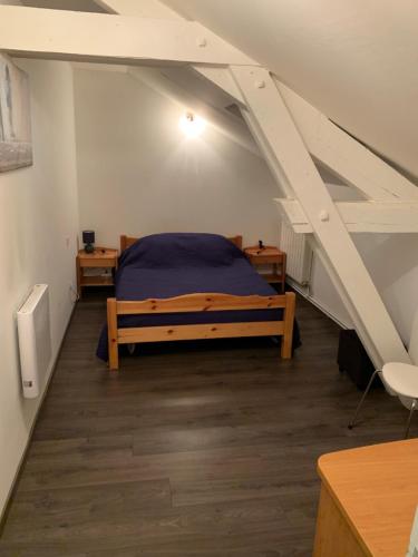 een slaapkamer met een bed op zolder bij Maison spacieuse tout confort in Meilhan