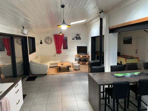a kitchen and living room with a couch and a table at Maison spacieuse tout confort 10 personnes in Meilhan