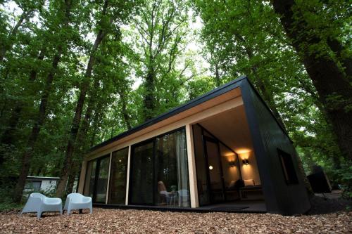 a small black house in the middle of a forest at Buitenplaats Petersburg in Arnhem