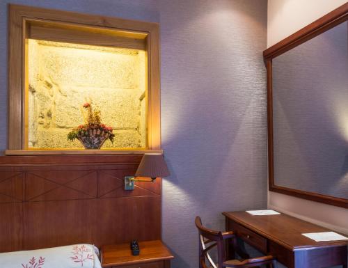 a bedroom with a mirror and a bed and a desk at Hotel Herradura in Santiago de Compostela