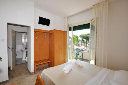 a bedroom with a bed and a view of a bathroom at Hotel Airone in Marina di Pietrasanta