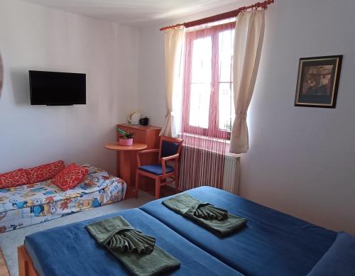 1 dormitorio con 2 camas, mesa y ventana en Pension Orbis, en Mariánské Lázně