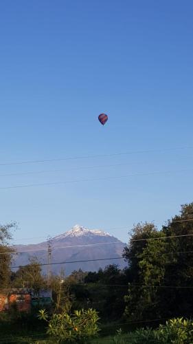 a plane flying in the sky over a mountain at Bellavista Casa de Huéspedes in San Pablo