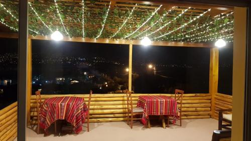 two tables and chairs on a balcony at night at Bellavista Casa de Huéspedes in San Pablo