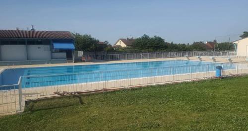 une grande piscine entourée d'une clôture. dans l'établissement Les fontaines, à Laives