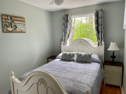 um quarto com uma cama branca e uma janela em Cozy LAKE ONTARIO WATERFRONT Breathtaking Views! em Pulaski