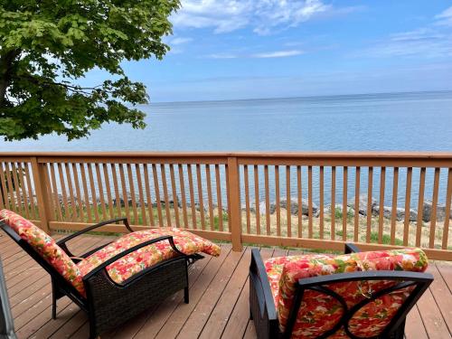two chairs on a deck with a view of the ocean at Cozy LAKE ONTARIO WATERFRONT Breathtaking Views! in Pulaski