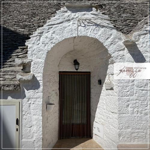 a door in a stone building with a gate at Trullo Fanizza in Alberobello