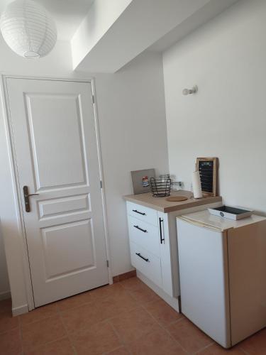 a kitchen with a white door and a counter top at Gîte La Pâquerie in Le Louroux-Béconnais