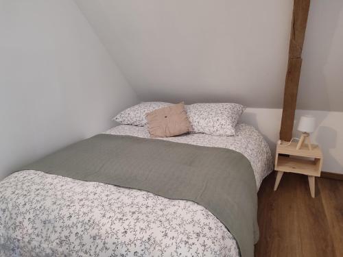 a small bedroom with a bed and a night stand at Gîte La Pâquerie in Le Louroux-Béconnais