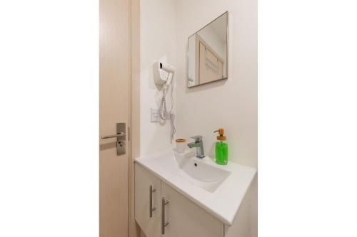 a bathroom with a white sink and a mirror at Boho Chic, Apart- condo cerca de SJO Intl airport in Barrial