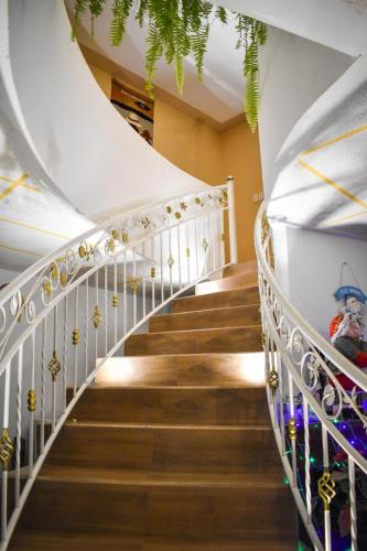 a spiral staircase with white railings and gold decorations at Bellavista Casa de Huéspedes in San Pablo