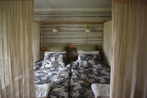 ein Bett in einem Zimmer mit Vorhängen und einem Bett sidx sidx sidx in der Unterkunft Esperöd Farm in Lilla Edet
