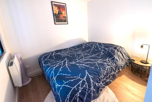 L’Arbre aux Hérons في نانت: غرفة نوم مع سرير مع لحاف أزرق
