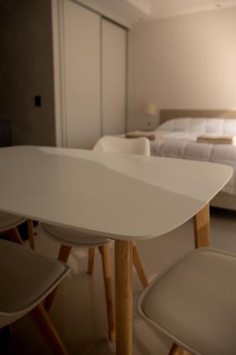 a white table and chairs in a room with beds at Apart France - Con Gim, Piscina y estacionamiento - Matrimonial in Río Cuarto