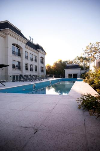 a swimming pool in front of a building at Apart France - Con Gim, Piscina y estacionamiento - Matrimonial in Río Cuarto