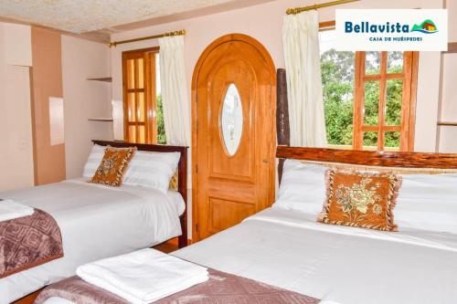 a bedroom with two beds and a window at Bellavista Casa de Huéspedes in San Pablo