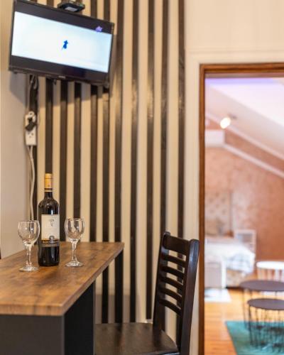 a table with a bottle of wine and two glasses at Delux Apartmani Požarevac in Požarevac