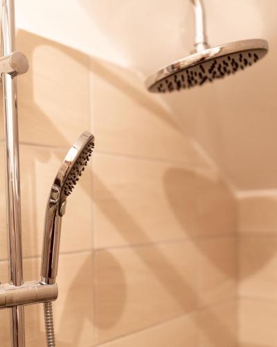 a shower with a shower head and a shower at Delux Apartmani Požarevac in Požarevac