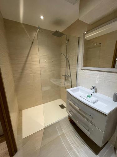 La salle de bains est pourvue d'une douche et d'un lavabo blanc. dans l'établissement 