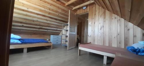 a room with two beds and a wooden wall at Mazurskie Wzgórze in Rydzewo