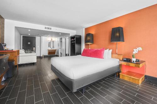 a bedroom with a large bed and a living room at The Fairwind Hotel in Miami Beach