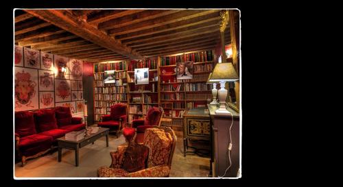 a living room with red furniture and bookshelves at Manoir de Livet in Saint-Germain-de-Livet