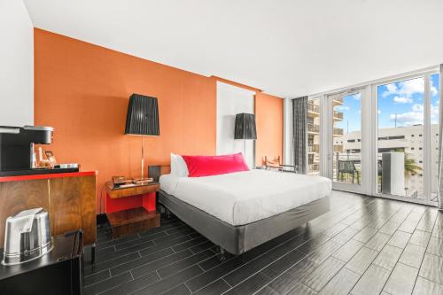 a bedroom with a large bed and a large window at The Fairwind Hotel in Miami Beach