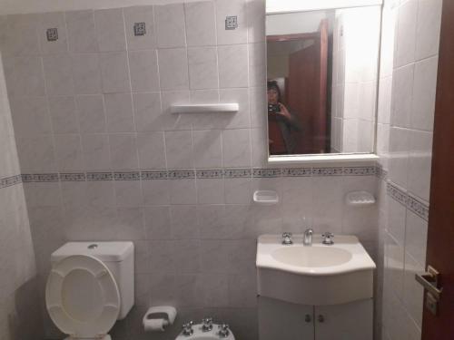una mujer tomando una foto de un baño con aseo y lavabo en Rent a Room Salta en Salta