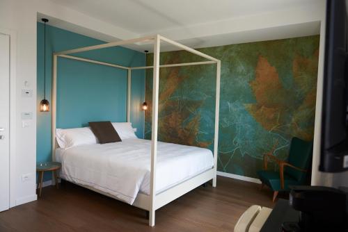 シルミオーネにあるHotel B&B il Mosaicoの青い壁のベッドルーム1室(天蓋付きベッド1台付)