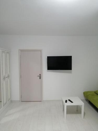 a white room with a door and a tv on a wall at Borlova /Muntele Mic in Borlova