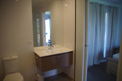 W łazience znajduje się umywalka, toaleta i lustro. w obiekcie The View on Grossmans w mieście Torquay