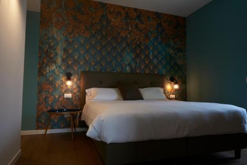 1 dormitorio con 1 cama grande y pared azul en Hotel B&B il Mosaico, en Sirmione