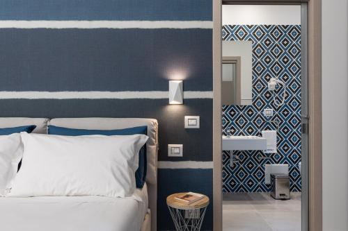 1 dormitorio con 1 cama y una pared azul y blanca en Torre Mola Suite en Formia