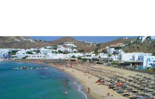 a beach with a lot of people and the ocean at demis Mykonos stay 2 in Platis Yialos Mykonos