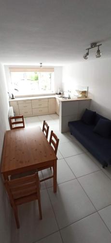 Una sala de estar con mesa y sillas y una cocina. en Oliwier, en Rewal