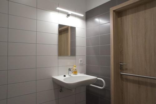 a white bathroom with a sink and a mirror at New Pension at ROTOR Brewery in Kunovice