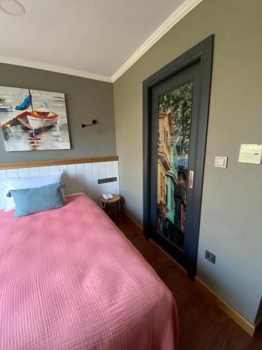 a bedroom with a pink bed and a window at Istanbul Old City Colorful Houses Balat PETRION Hotel in Istanbul
