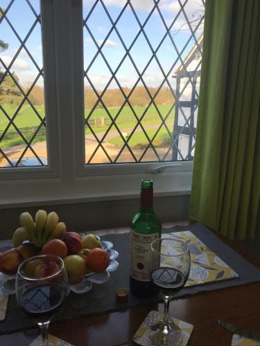 a table with two glasses and a bottle of wine at Round-y-Corner in Macclesfield
