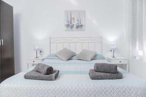 1 dormitorio blanco con 1 cama con 2 toallas en Cambrils Beach & Sea, en Cambrils