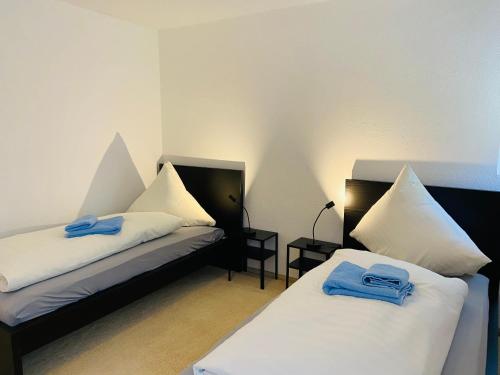 2 łóżka w pokoju z niebieskimi ręcznikami w obiekcie Quartier48 - 2 Stadtapartments oder das ganze Haus bis 9 Personen w mieście Suhl