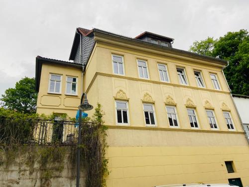 a yellow building with windows on top of a wall at Quartier48 - 2 Stadtapartments oder das ganze Haus bis 9 Personen in Suhl