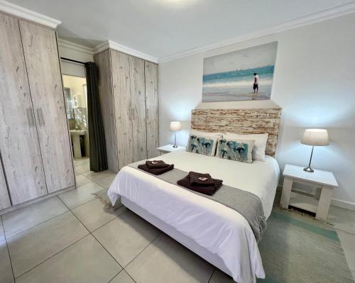 una camera con un grande letto e un dipinto sul muro di Always Summer Guesthouse a Langebaan