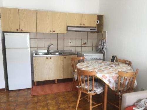 een keuken met een tafel en een witte koelkast bij Casa Lu’ in Mongiove