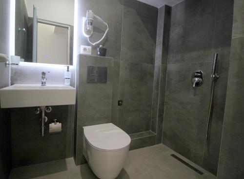 a bathroom with a shower and a toilet and a sink at Art De Jon Rooms in Sarandë