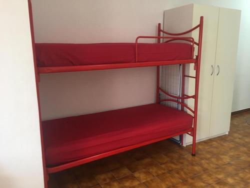 een paar rode stapelbedden in een kamer bij Casa Lu’ in Mongiove