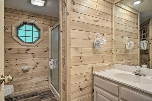 a bathroom with wooden walls and a sink and a shower at Furnished Deck and Grill Rustic Pigeon Forge Cabin in Pigeon Forge